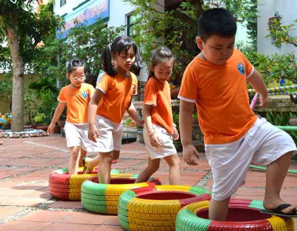 Mẫu đồng phục cổ tròn áo màu cam kết hợp quần trắng, tay áo bo viền khác màu đẹp mắt